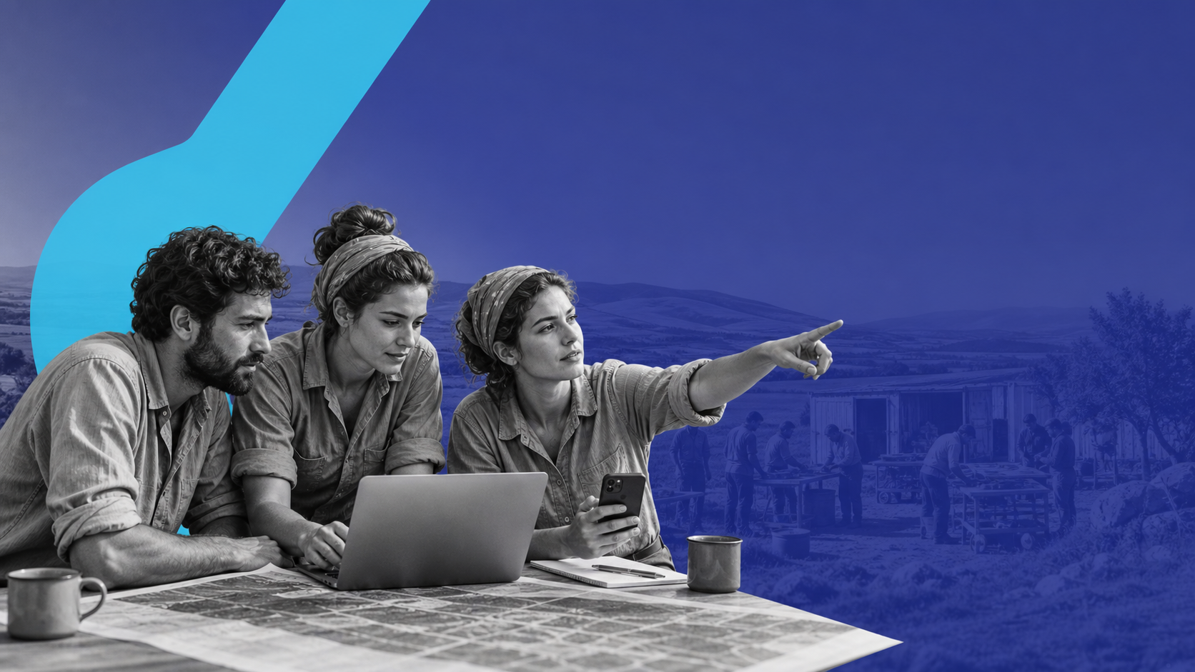 צוות מתנדבי טכנולוגיה יושב סביב מפה ולפטופ בשטח